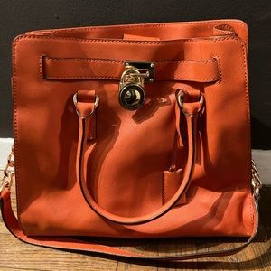 Michael Kors orange leather handbag with gold embellishments